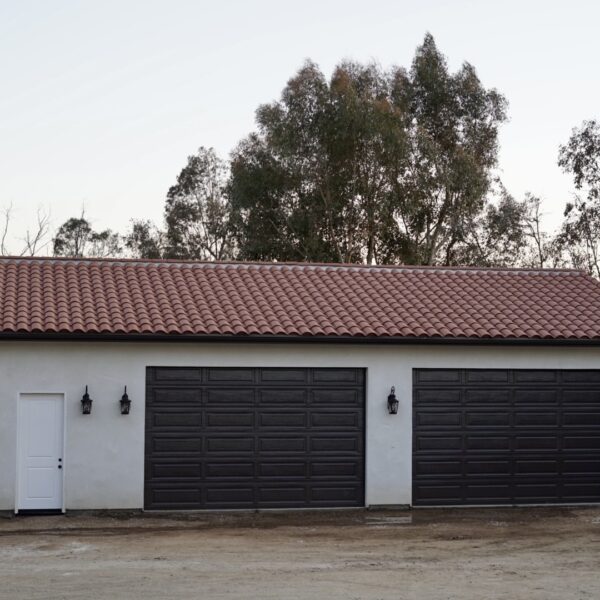 A garage with black doors and a red roof
