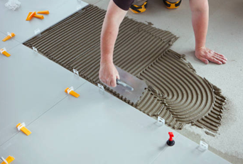 A man spreading the cement evenly on the floor